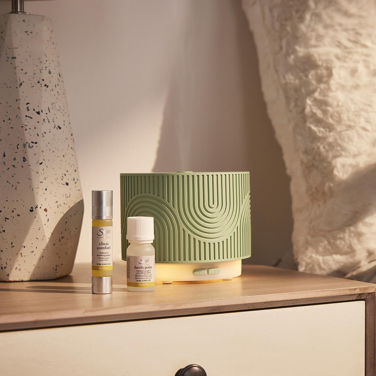 Aroma Nook pistachio sits on a dresser with Chest Comfort roll-on and Fortify Petite diffuser blend