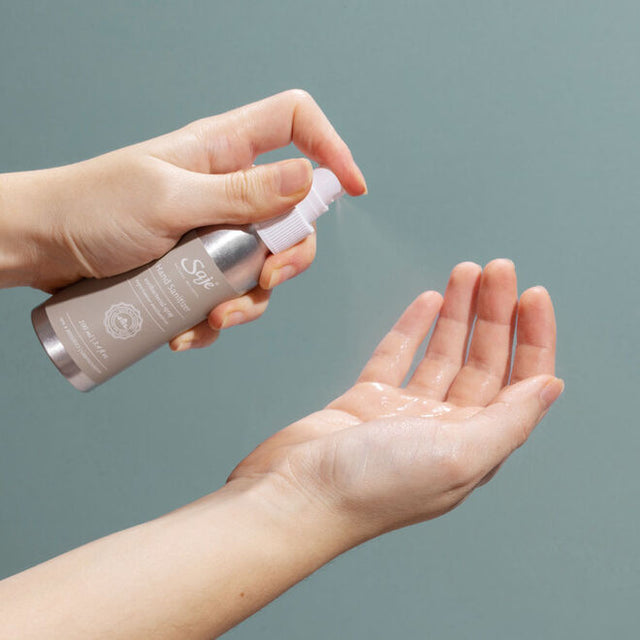 A person spraying the Hand Sanitizer antibacterial spray into their hands 