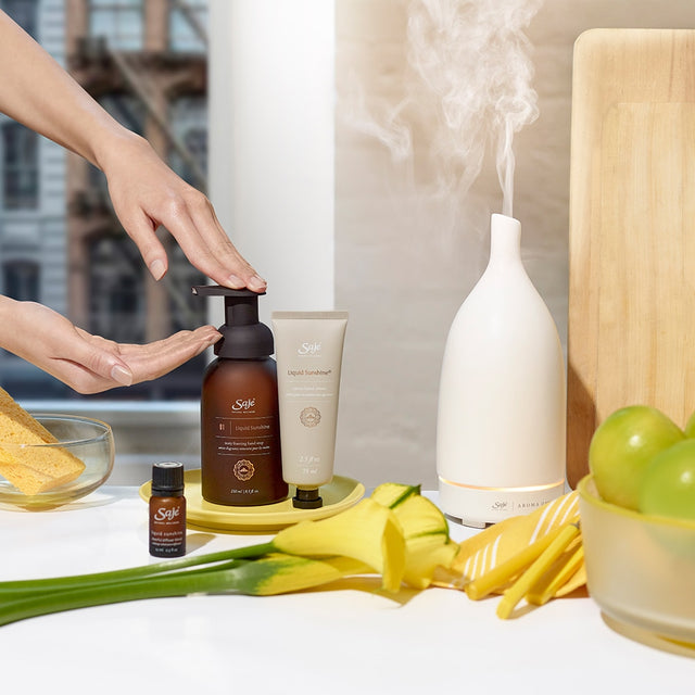 Liquid Sunshine Hand Cream beside hand pumping Liquid Sunshine Soap into hand in bathroom