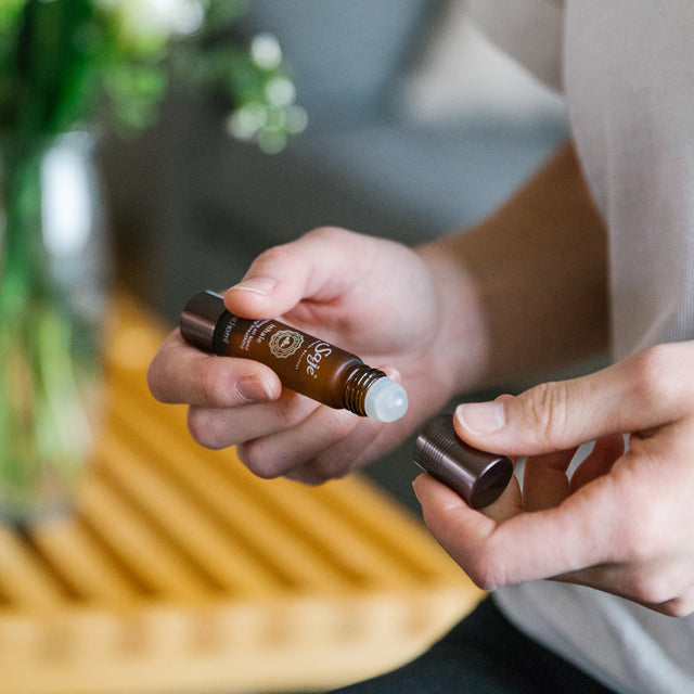 A person removing the lid of the Inhale soothing oil blend roll-on 0.34 fl oz 