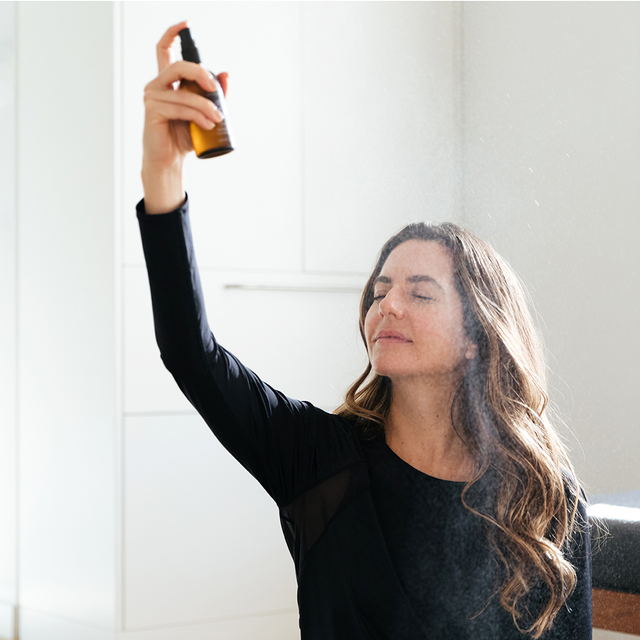 A person spraying the Fortify mist on their face 